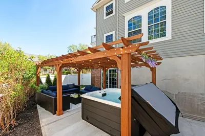 a hot tub in a backyard with a wooden pergola at NYC 20min Free Parking Hot Tub EWR 15min in Bayonne