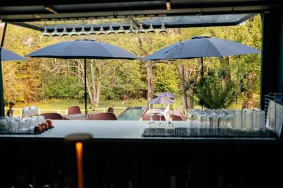 a table with chairs and umbrellas next to a pool at The Rest Suite 5 in Kenoza Lake