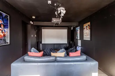 a blue couch with colorful pillows in a room at Mahogany Sun Hot Tub Theater Room Fire Pit in East Stroudsburg