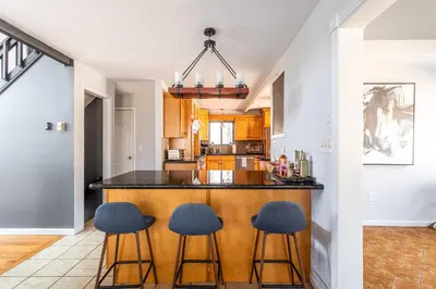 a kitchen with two bar stools and a counter top at Mahogany Sun Hot Tub Theater Room Fire Pit in East Stroudsburg