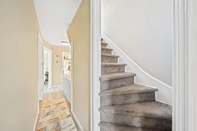 a staircase in a home with white walls at Comfort, Fun, and Retro Retreat in Royersford
