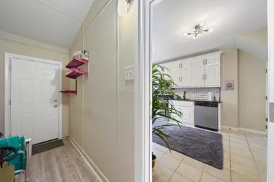 a kitchen with white cabinets and a plant in a room at Comfort, Fun, and Retro Retreat in Royersford