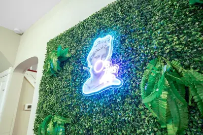 a wall covered in plants with a painting on it at Comfort, Fun, and Retro Retreat in Royersford