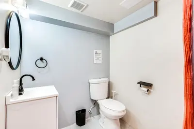 a bathroom with a toilet and a sink and a mirror at Game Room, Deck and Fire Pit Covington Township Gem in Daleville