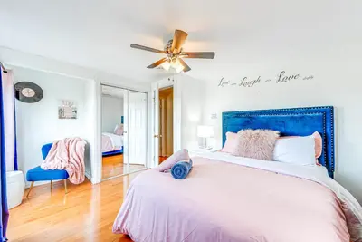 a bedroom with a large bed with a blue headboard at Game Room, Deck and Fire Pit Covington Township Gem in Daleville