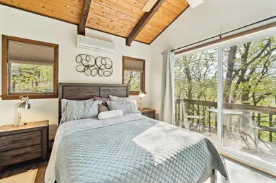 a bedroom with a bed and a large window at Charming Porter House in the heart of the Poconos chalet in East Stroudsburg