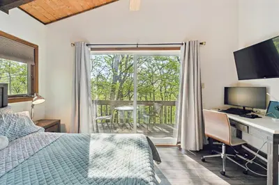 a bedroom with a bed and a desk with a computer at Charming Porter House in the heart of the Poconos chalet in East Stroudsburg