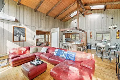 a living room with a red leather couch and a table at Charming Porter House in the heart of the Poconos chalet in East Stroudsburg