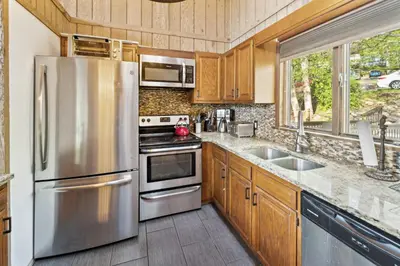 a kitchen with a stainless steel refrigerator and a sink at Charming Porter House in the heart of the Poconos chalet in East Stroudsburg