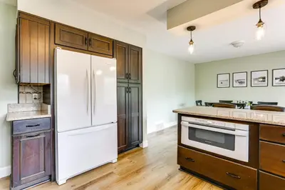 a kitchen with a white refrigerator and wooden cabinets at half Mi to Boat Ramp Lake Wallenpaupack Retreat! in Lakeville