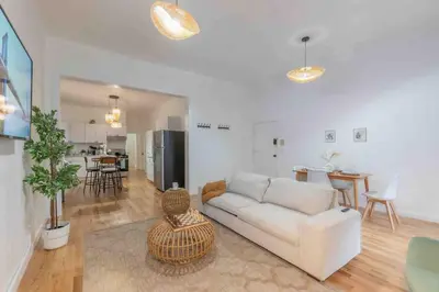 a living room with a white couch and a kitchen at City Escape with 2 Baths, 10 beds and We Pay Half Parking for 2 cars, NYC in 15 min in Hoboken