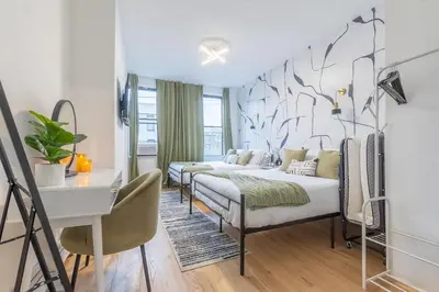 a bedroom with two beds and a desk in it at City Escape with 2 Baths, 10 beds and We Pay Half Parking for 2 cars, NYC in 15 min in Hoboken