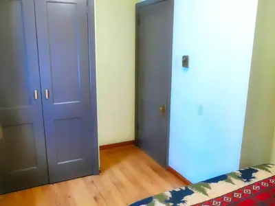 a bedroom with two doors and a bed and wooden floors at Lakefront Cabin Rental with Incredible Sunsets on Lake Wallenpaupack, Pennsylvania in Hawley