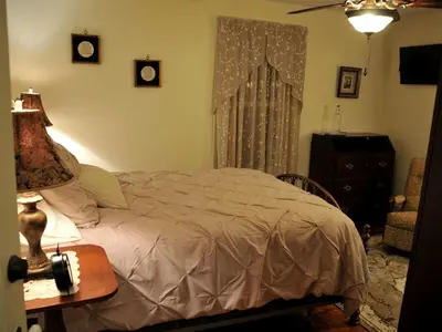 a bedroom with a bed and a table with a lamp at Spacious Cottage Rental with Creek Views near Harrisburg and Hershey, Pennsylvania in Middletown