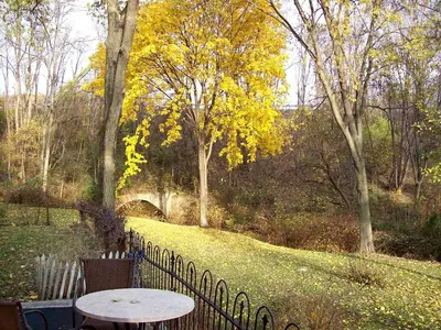 a table and chairs sitting next to a fence at Spacious Cottage Rental with Creek Views near Harrisburg and Hershey, Pennsylvania in Middletown