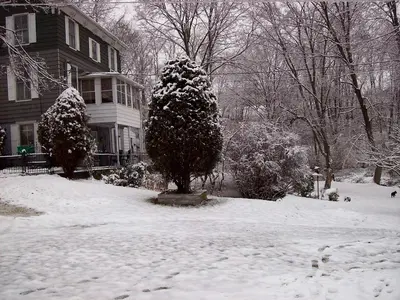 a snow covered yard in front of a house at Spacious Cottage Rental with Creek Views near Harrisburg and Hershey, Pennsylvania in Middletown