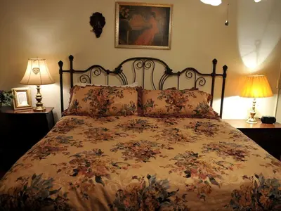 a bedroom with a bed with a floral bedspread and two lamps at Spacious Cottage Rental with Creek Views near Harrisburg and Hershey, Pennsylvania in Middletown