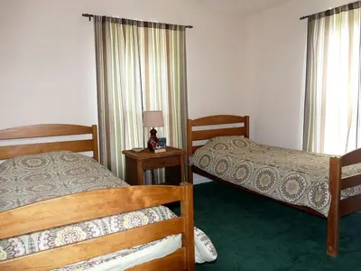 a bedroom with two beds and a lamp on a table at Lakefront Vacation Rental with Superb Views over Lake Wallenpaupack in Hawley, Pennsylvania in Hawley