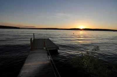 a dock in the middle of a lake at sunset at Lakefront Vacation Rental with Superb Views over Lake Wallenpaupack in Hawley, Pennsylvania in Hawley