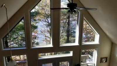 a room with four windows and a ceiling fan at Lakefront Vacation Rental with Superb Views over Lake Wallenpaupack in Hawley, Pennsylvania in Hawley