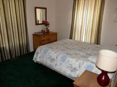a bedroom with a bed and a table with a lamp at Lakefront Vacation Rental with Superb Views over Lake Wallenpaupack in Hawley, Pennsylvania in Hawley