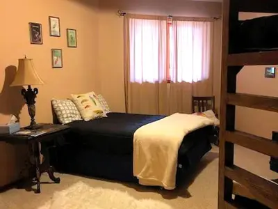a bedroom with a bed and a bunk bed at Stunning Cabin Rental with a Hot Tub Overlooking Fishing Creek near Sproul State Forest, Pennsylvania in Mill Hall