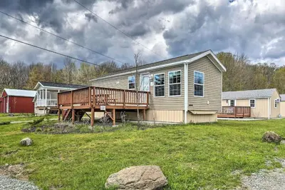 a house with a deck on a yard at Great Vacation Complex for the Best Pennsylvania Glamping in Scranton