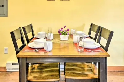 a wooden table with chairs and plates and flowers on it at Remote Ski Rentals for a Gorgeous Pennsylvania Retreat in Pleasant Mount