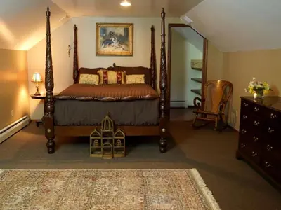 a bedroom with a canopy bed and a rug at Spacious Villa Rental with a Pool for a Large Group near Catskill Mountains, New York in Fishs Eddy