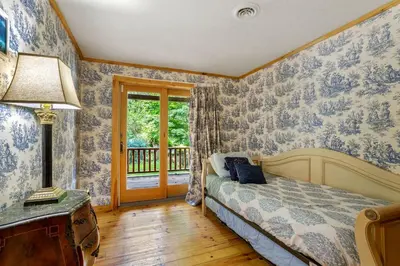 a bedroom with a bed with blue and white wallpaper at Spacious Villa Rental with a Pool for a Large Group near Catskill Mountains, New York in Fishs Eddy