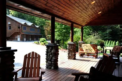 a porch with chairs and a wooden roof at Spacious Villa Rental with a Pool for a Large Group near Catskill Mountains, New York in Fishs Eddy