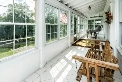 an empty porch with a bench and windows at 27-Person Luxury Villa Rental in Hudson Valley, New York in Monroe