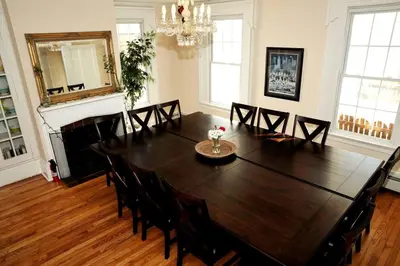 a dining room with a large wooden table and chairs at 27-Person Luxury Villa Rental in Hudson Valley, New York in Monroe