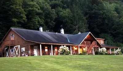 a barn with a black roof on a green field at Fantastic Secluded Rental for a Large Group Getaway near East Branch, New York in Fishs Eddy