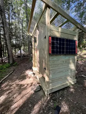 a wooden outhouse with a window on the side of it at Amazing Equipped Bell Tent Nestled Among Nature in New York in Kerhonkson