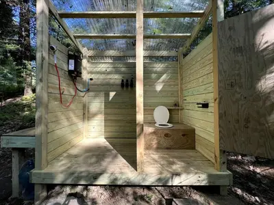 a wooden out house with a toilet in it at Amazing Equipped Bell Tent Nestled Among Nature in New York in Kerhonkson