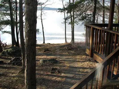 a wooden path leading to the water with trees at Idyllic Waterfront Log Cabin in Wayne County Overlooking Lake Wallenpaupack, Pennsylvania in Lakeville