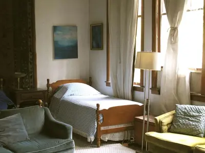 a bedroom with a bed and a chair and a window at Historic Vacation Rental with Music Studio in the Catskills near Hancock, New York in Hancock