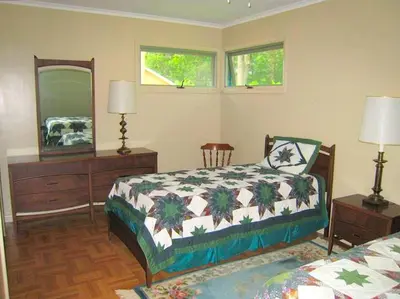a bedroom with a bed and a dresser and a mirror at Peaceful Private Cabin on Crystal Lake near Elk Mountain, Pennsylvania in Clifford