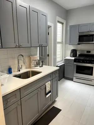 a kitchen with gray cabinets and a sink at Adventures In NYC Only 10 Mins to NYC in Union City