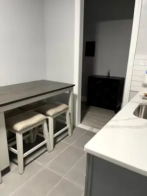 a kitchen with a table and two stools and a sink at Adventures In NYC Only 10 Mins to NYC in Union City