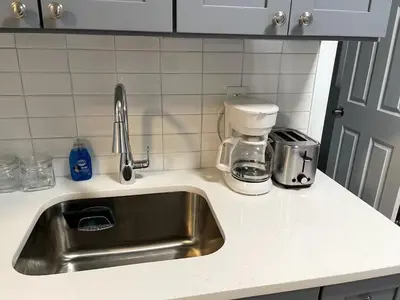 a kitchen counter with a sink and a coffee maker at Adventures In NYC Only 10 Mins to NYC in Union City