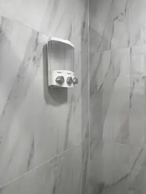 a bathroom with a soap dispenser on a wall at Adventures In NYC Only 10 Mins to NYC in Union City