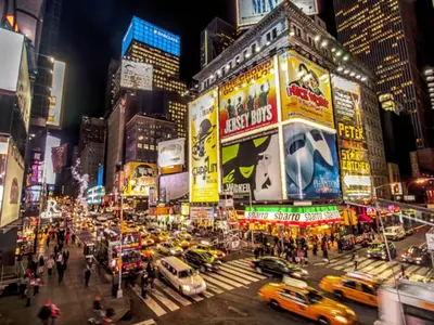 a busy city street at night with cars and taxis at Sweet Diamonds & Adventures 10 Mins To NYC in Union City