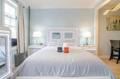 a bedroom with a large white bed with two lamps at Sweet Diamonds & Adventures 10 Mins To NYC in Union City
