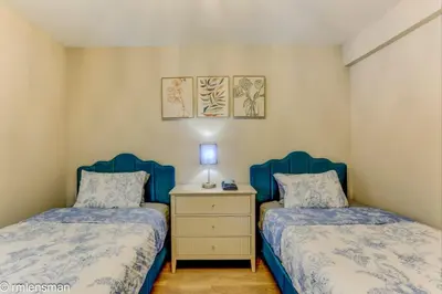 a bedroom with two beds and a night stand with a lamp at The Hut House 3BR 3BA Game Room Massage Chair in Lake Ariel