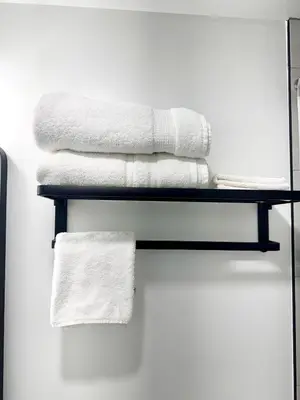 a group of towels on a shelf in a bathroom at Cozy 3BR Retreat with Rooftop Near EWR & NYC Access in Newark