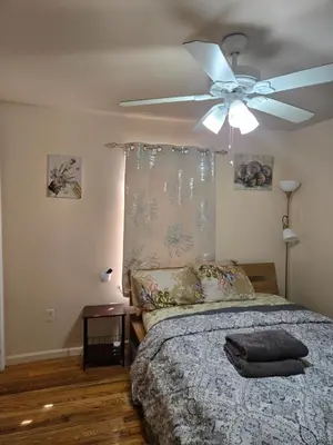 a bedroom with a ceiling fan and a bed at Joy queen room 6A in Newark