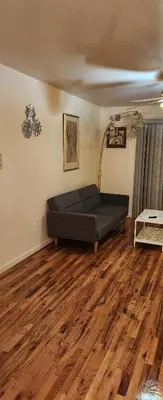 a bed in a room with a wooden floor at Joy queen room 6A in Newark