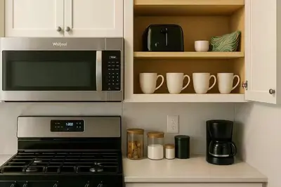 a kitchen with a microwave and some cups and mugs at Warm & Cozy Escape - NYC & NWK with Free Parking in Bayonne